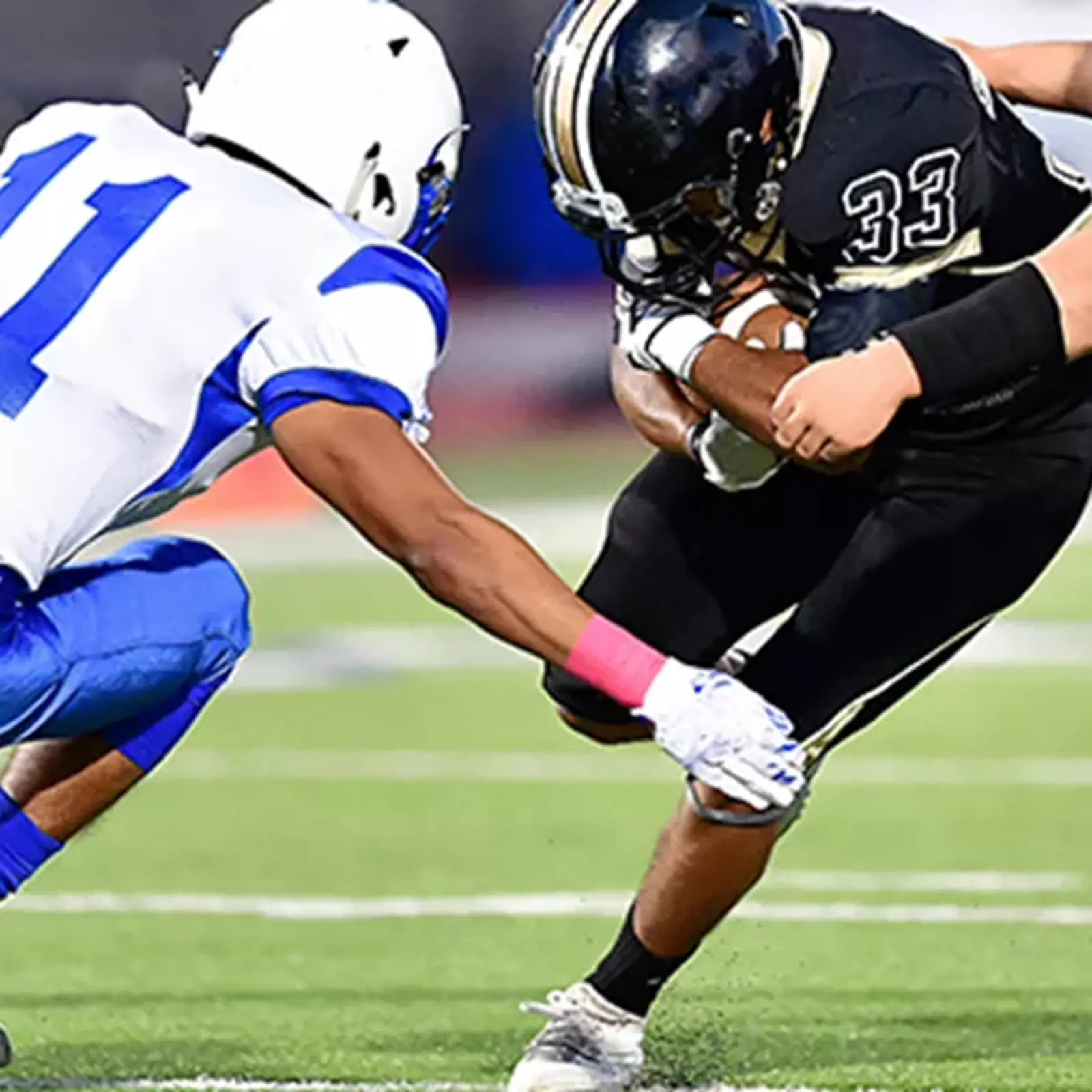 Professional athletes playing football on sports turf field that utilizes high performance BESTSAND athletic sand made with safety and performance as top priority.