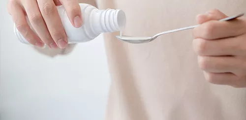 antacid pouring onto a spoon