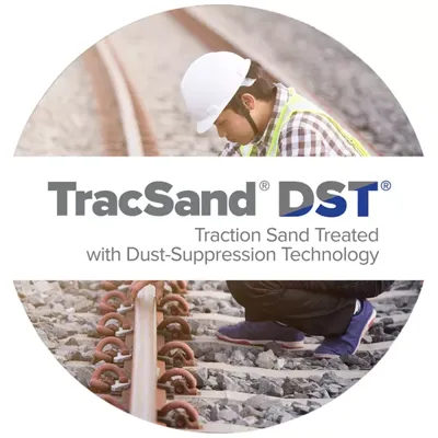 Rail way worker is working on rail road where TRACSAND traction sand that has been treated with DST dust suppression technology is being used on rail tracks to create a safer environment for the employee.