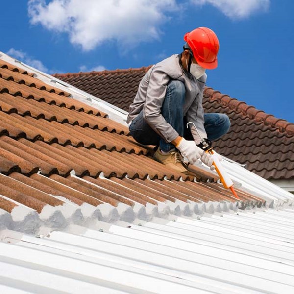 Construction roofer worker applying sealant and adhesives with HIFILL calcium carbonate filler for whiteness and cost effective high performance.