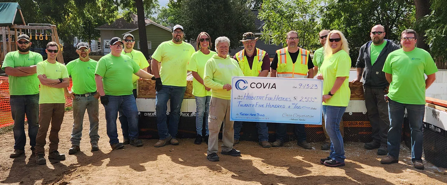 people holding a large check from Covia