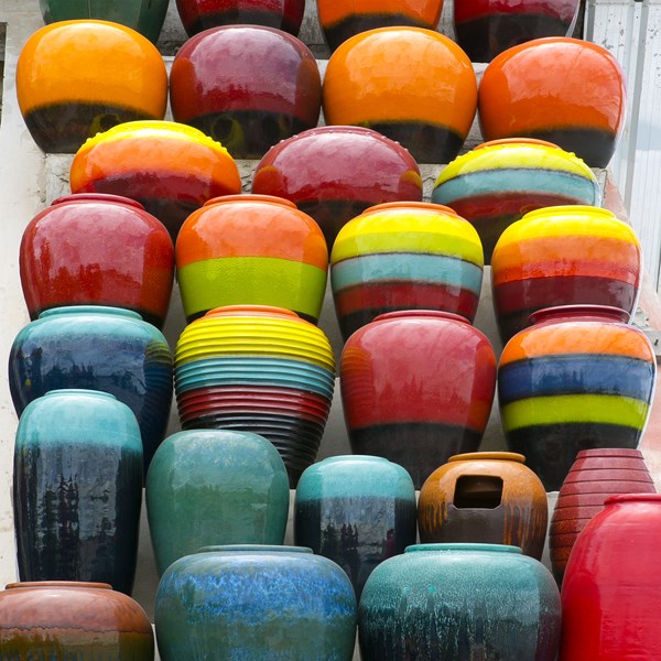 Stacks of colorful ceramic pots and ceramicwares made using ceramic flux created with MAXUM sodium feldspar, created with high purity feldspathic feedstock and known for producing strong and stable ceramic pieces.