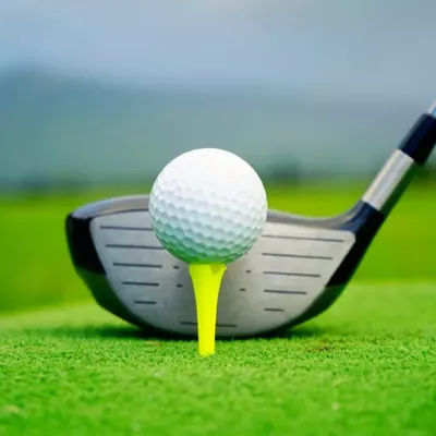 Vibrant white bunker sand with close up of golfer hitting golf ball with club.